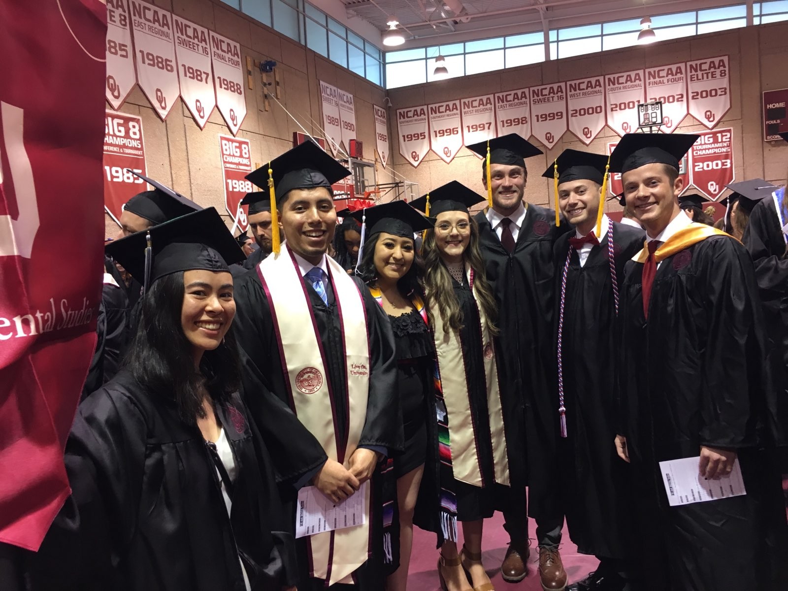 Seven students in caps and gowns