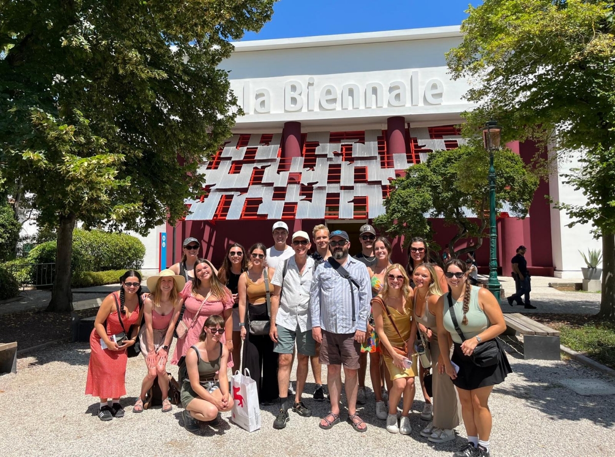 A group of 15 OU students and two OU professors stand outside of the Venice Biennale in Italy at the conclusion of an OU study abroad program.