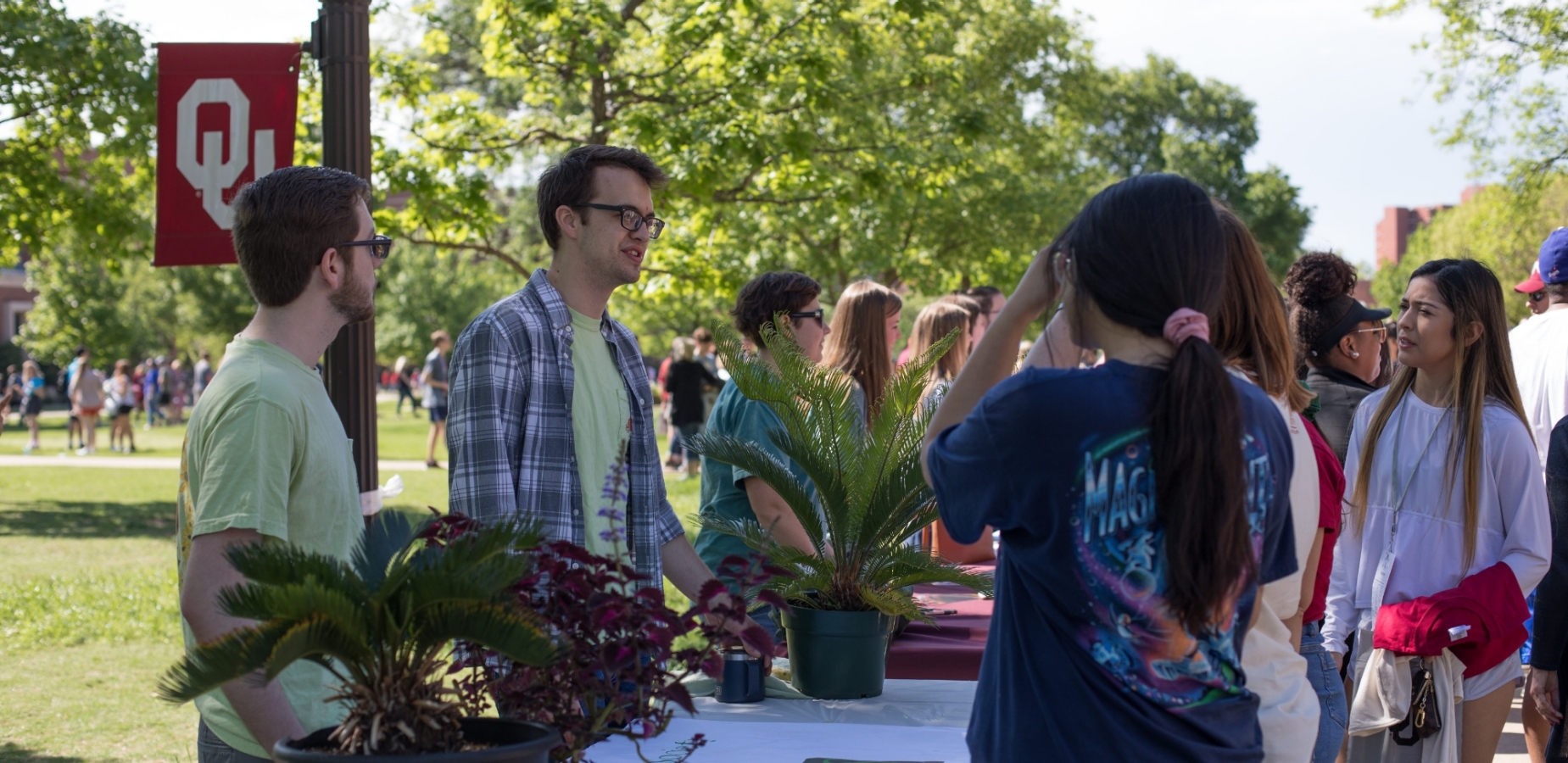 A group of Environmental Studies students stands at a table on the South Oval and speaks with prospective students on Sooner Saturday.