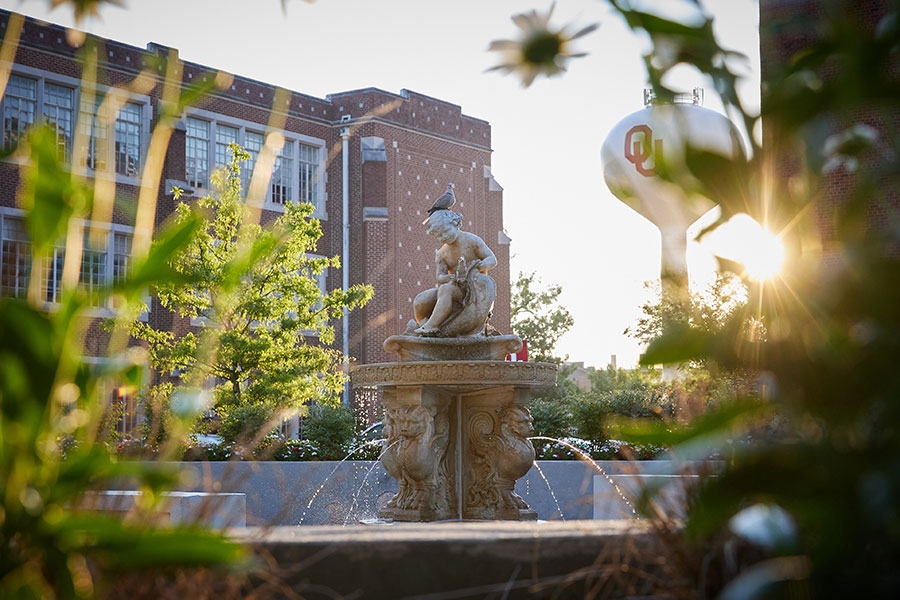 Summer sunrise with a fountain in the foreground and the O U water tower in the background.
