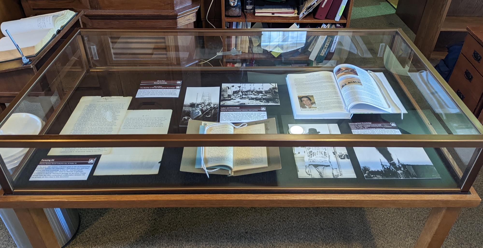 Photograph of glass exhibit display box with several documents on display inside.