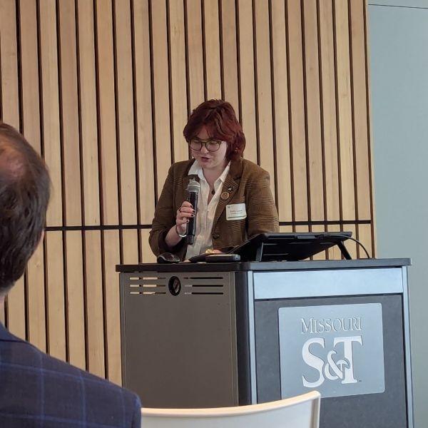 Emily Laiben presenting at a podium with the Missouri S and T University logo on the front of the podium.