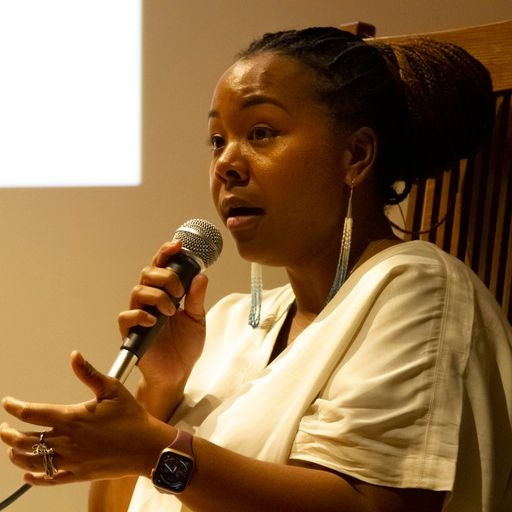 A woman holding a microphone speaks at a Roe vs. Wade panel discussion.