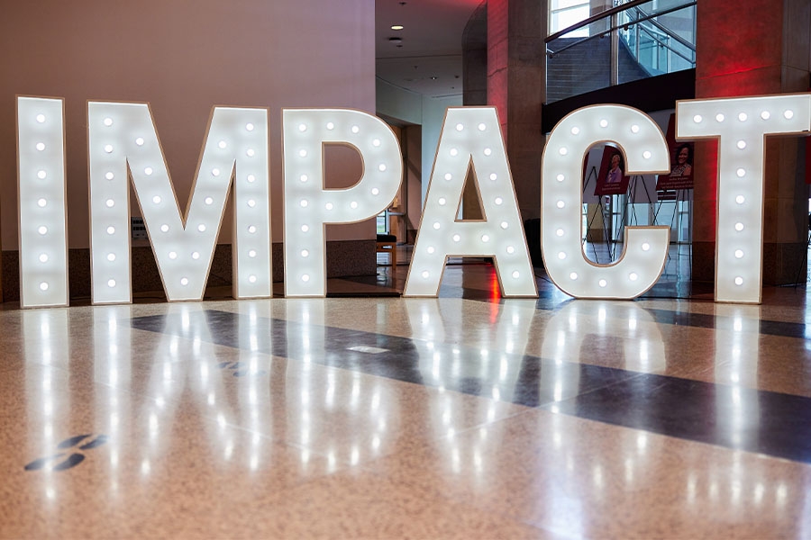 Large lighted letter decorations that say impact.