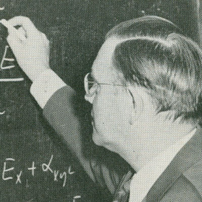 A black and white photo of Dr. Nielsen at the chalkboard.