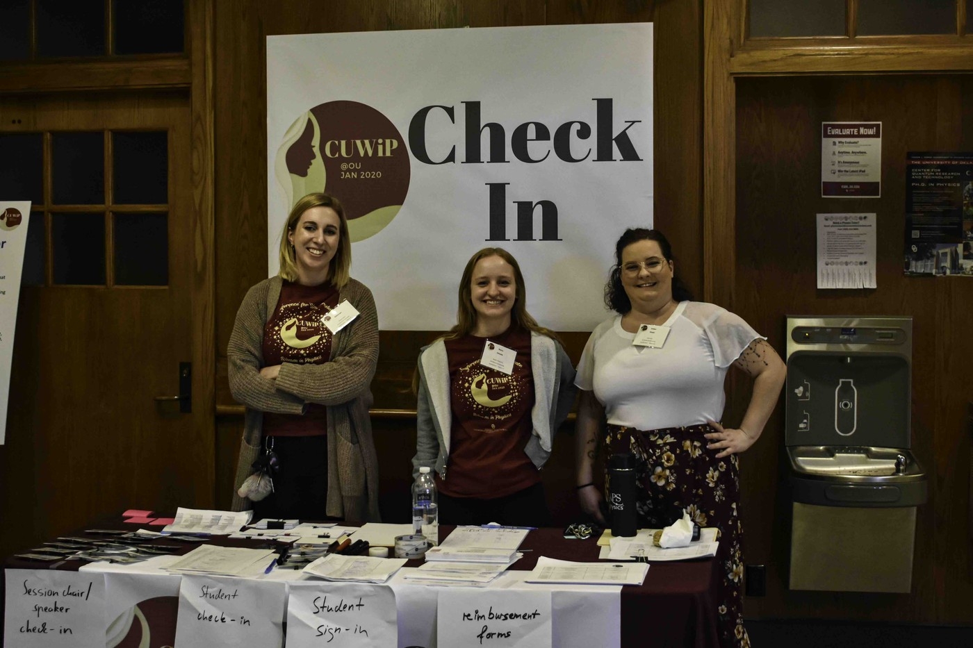 A photo of three people at the Check In booth.