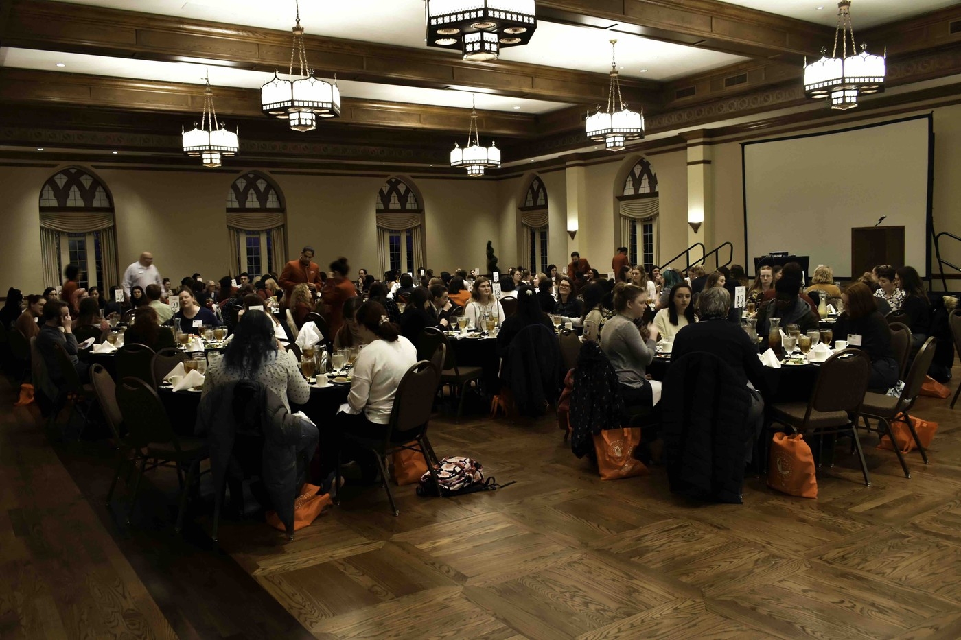People sit at tables ready to enjoy a meal.