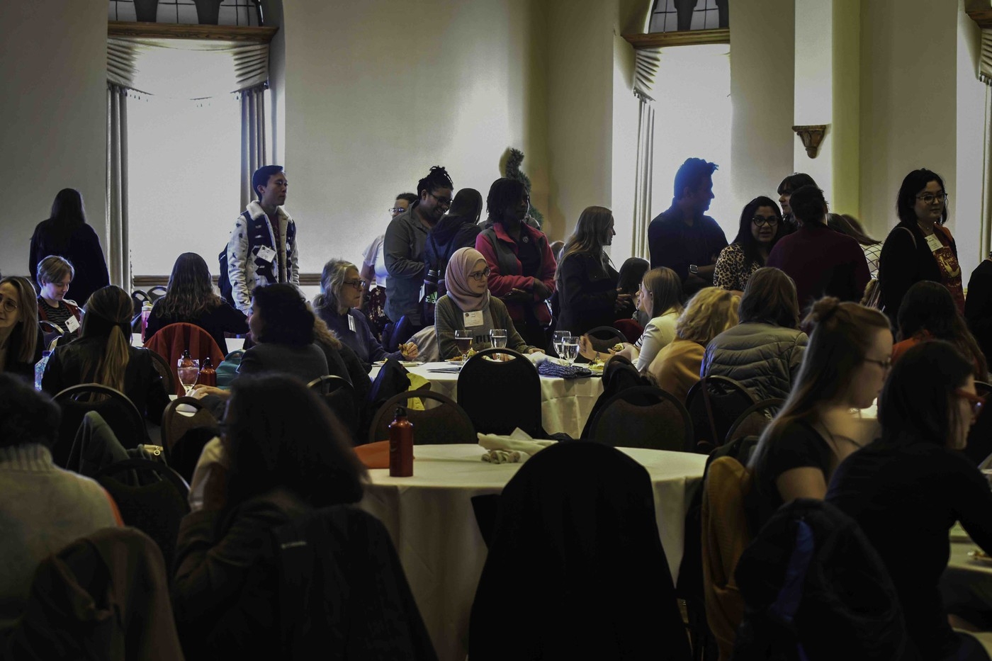 People sit at tables ready to enjoy a meal.