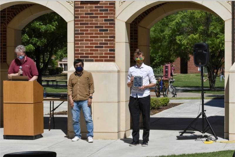 A photo of Simon Lowry accepting their award.