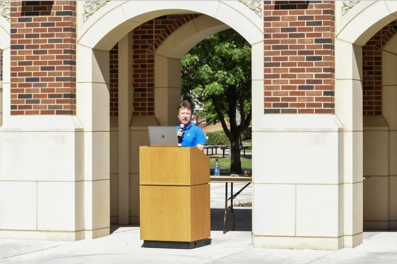 A photo of Michael Strauss at the podium.