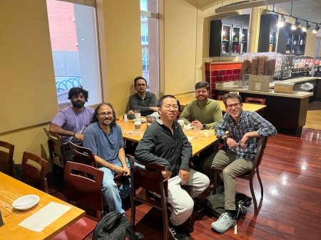 A small group from the High Energy Physics research group enjoying a meal at a restaurant.