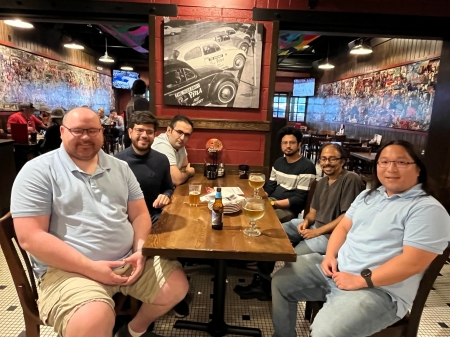 A small group from the High Energy Physics research group enjoying a meal at a restaurant.