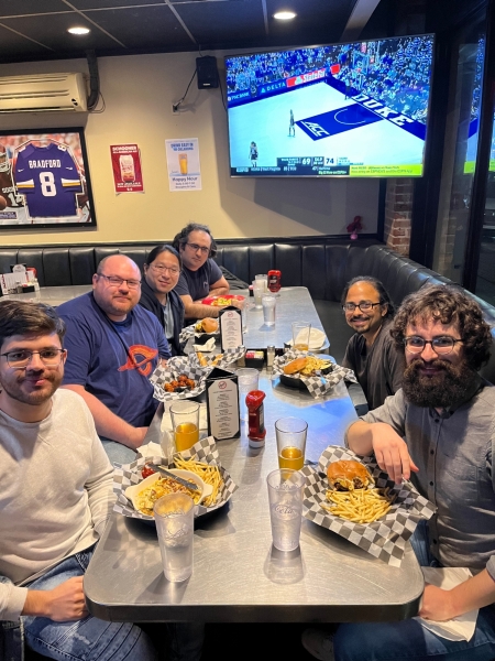 A small group from the High Energy Physics research group enjoying a meal at a restaurant.