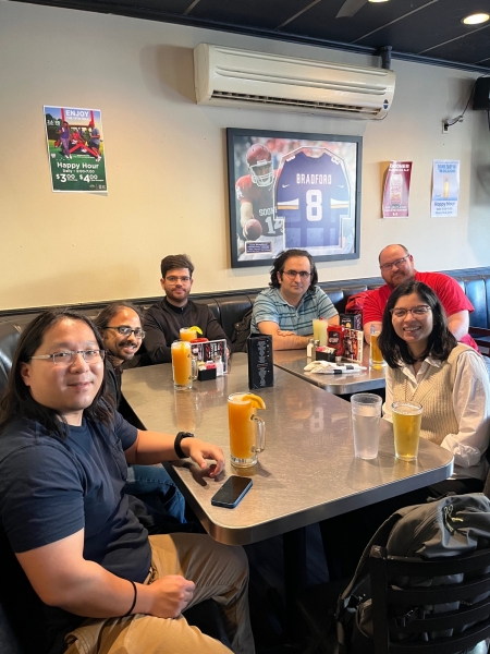 A small group from the High Energy Physics research group enjoying a meal at a restaurant.