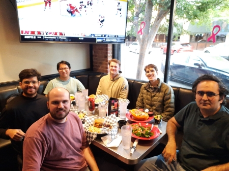 A small group from the High Energy Physics research group enjoying a meal at a restaurant.
