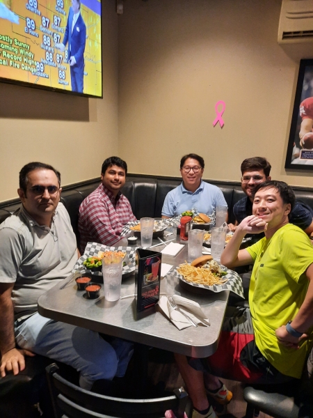 A small group from the High Energy Physics research group enjoying a meal at a restaurant.