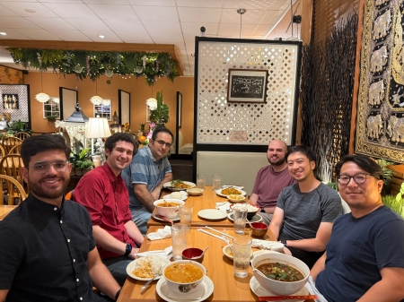 A small group from the High Energy Physics research group enjoying a meal at a restaurant.