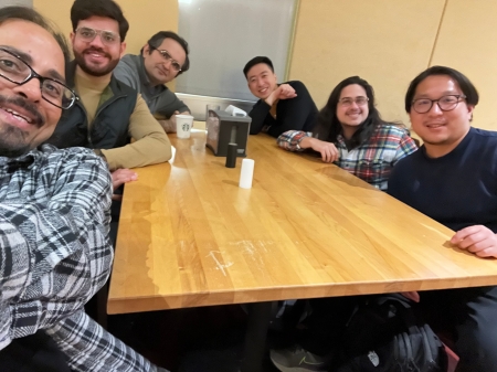 A small group from the High Energy Physics research group enjoying a meal at a restaurant.