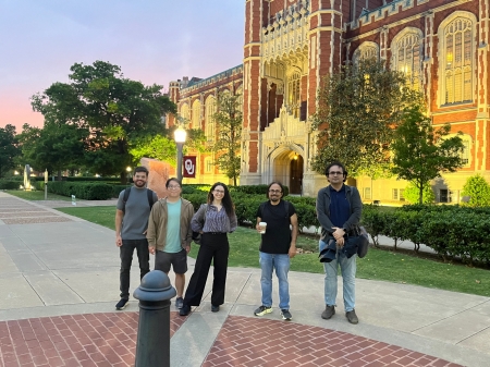 A small group from the High Energy Physics research group pose for a picture in front of the OU library.