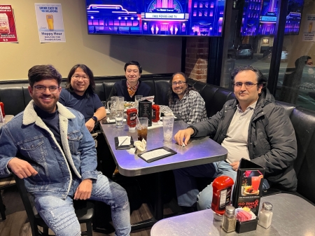 A small group from the High Energy Physics research group enjoying a meal at a restaurant.