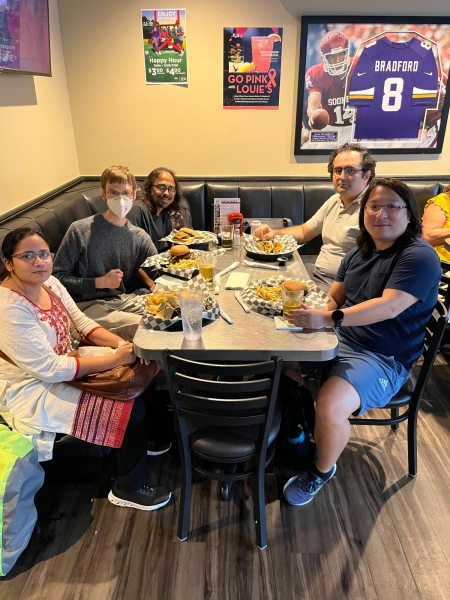 A small group from the High Energy Physics research group enjoying a meal at a restaurant.