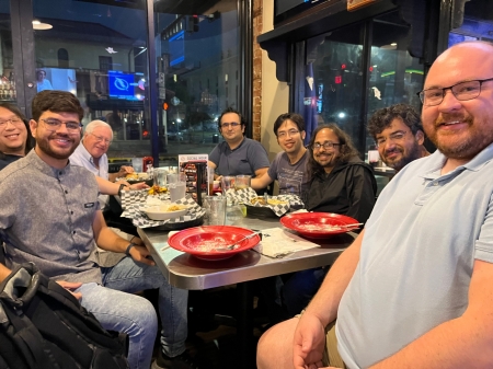 A small group from the High Energy Physics research group enjoying a meal at a restaurant.