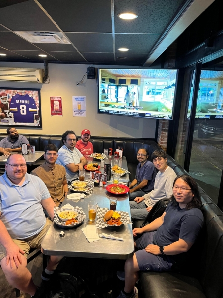 A small group from the High Energy Physics research group enjoying a meal at a restaurant.
