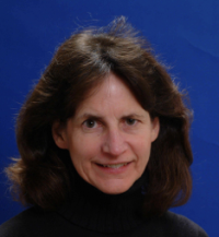 Photo of Deborah Watson smiling against a blue backdrop.