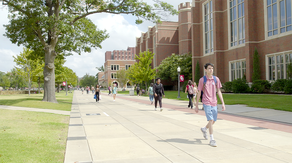 Students walking on south oval sidewalk.