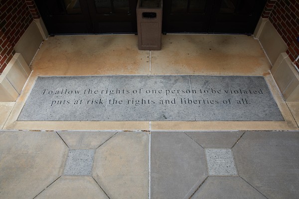 Inspirational quote cut in the granite floor of a door threshold.