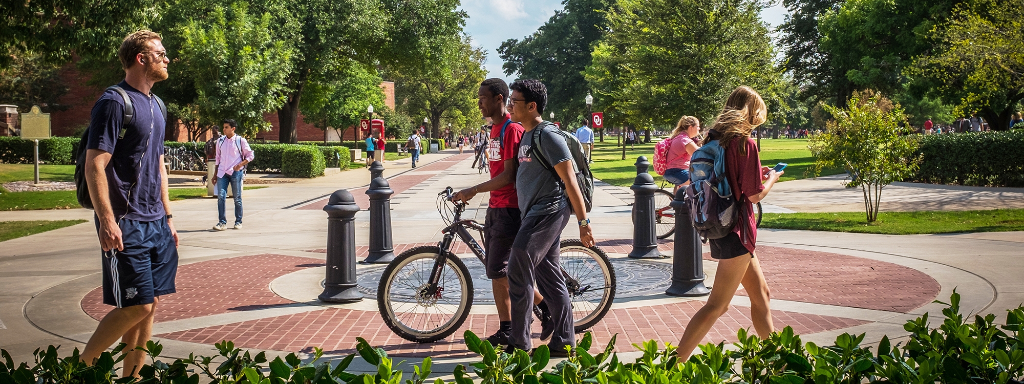 Students walking and biking on O U's campus.