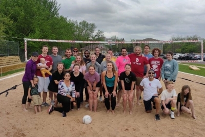 Group photo of psychology graduate students, faculty, and friends playing volleyball