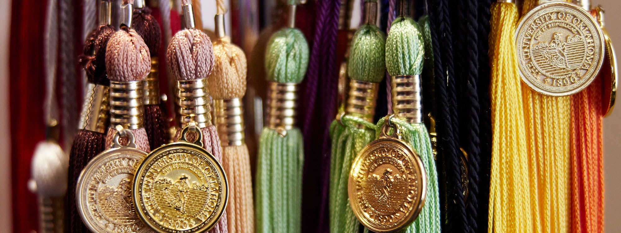 OU tassels in a rainbow of colors, featuring a coin imprinted with the OU seal.