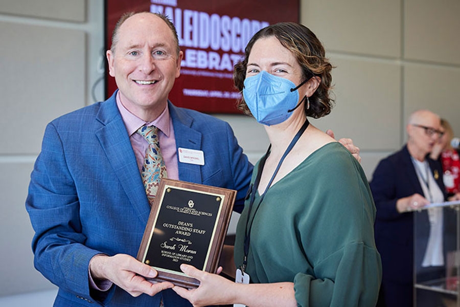 A photo of Sarah Moran being presented with a plaque by Dean David Wrobel. 