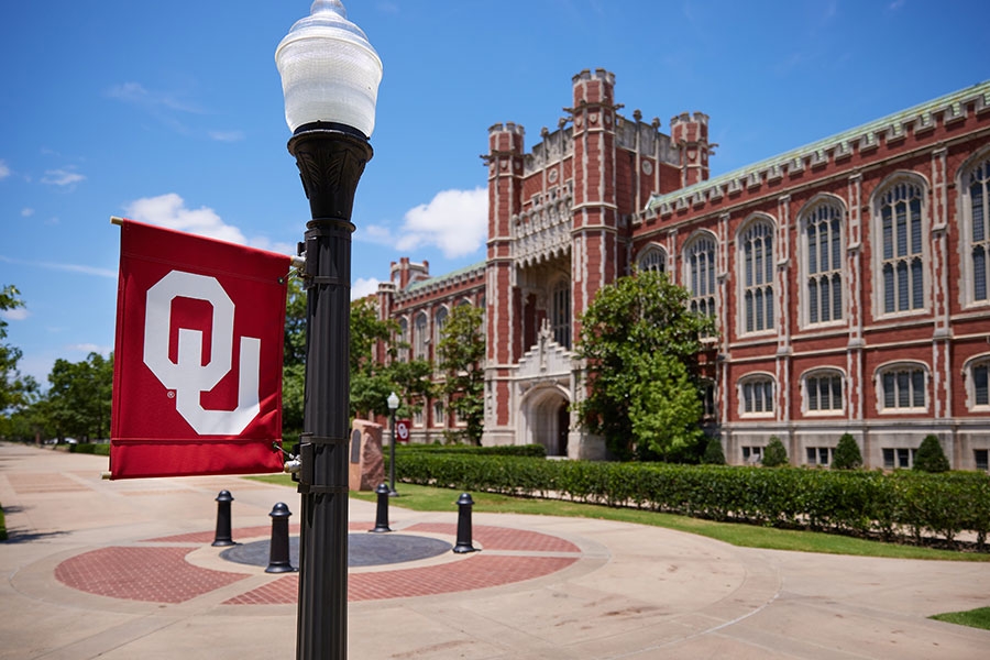 A view of the south entrance to Bizzell Library framed by an OU lamppost.