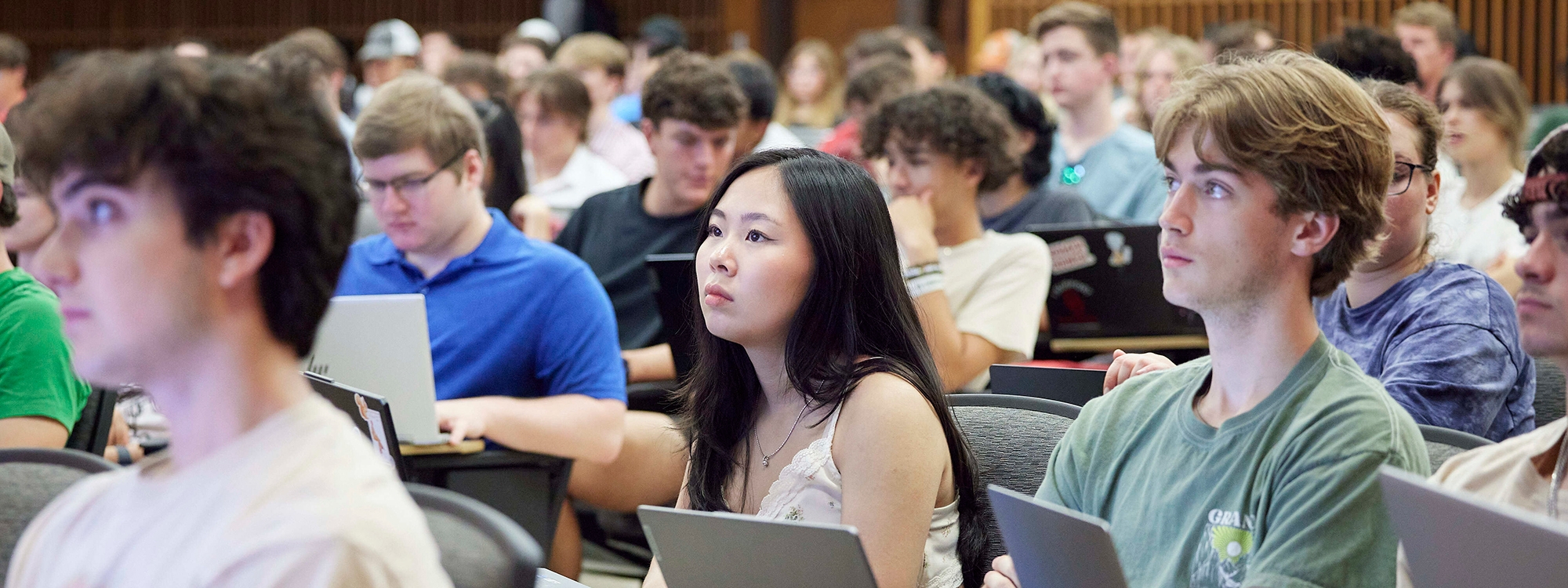 Students sitting in an auditorium, attending a lecture.