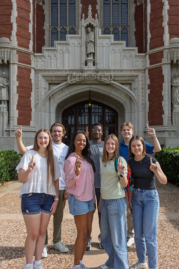 Students in front of entrance to Library on campus.