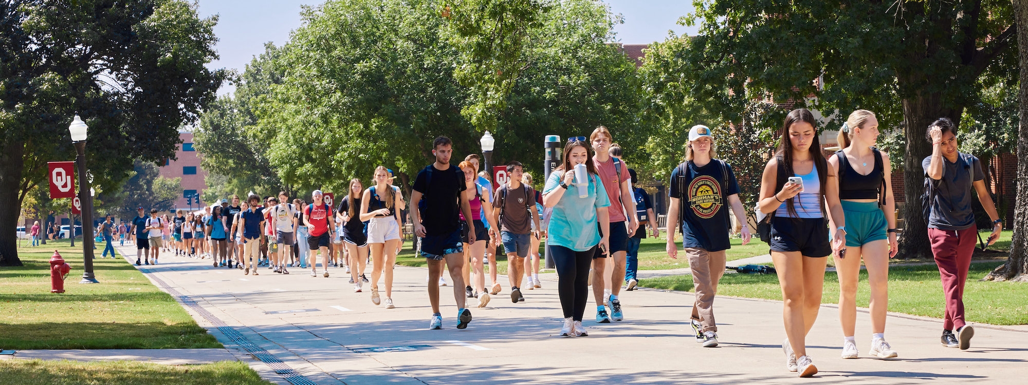 Numerous students walking to classes on OU campus.