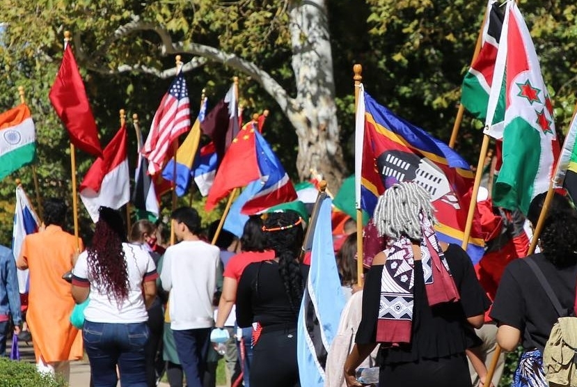Students walking on the OU campus with their country flags in hand