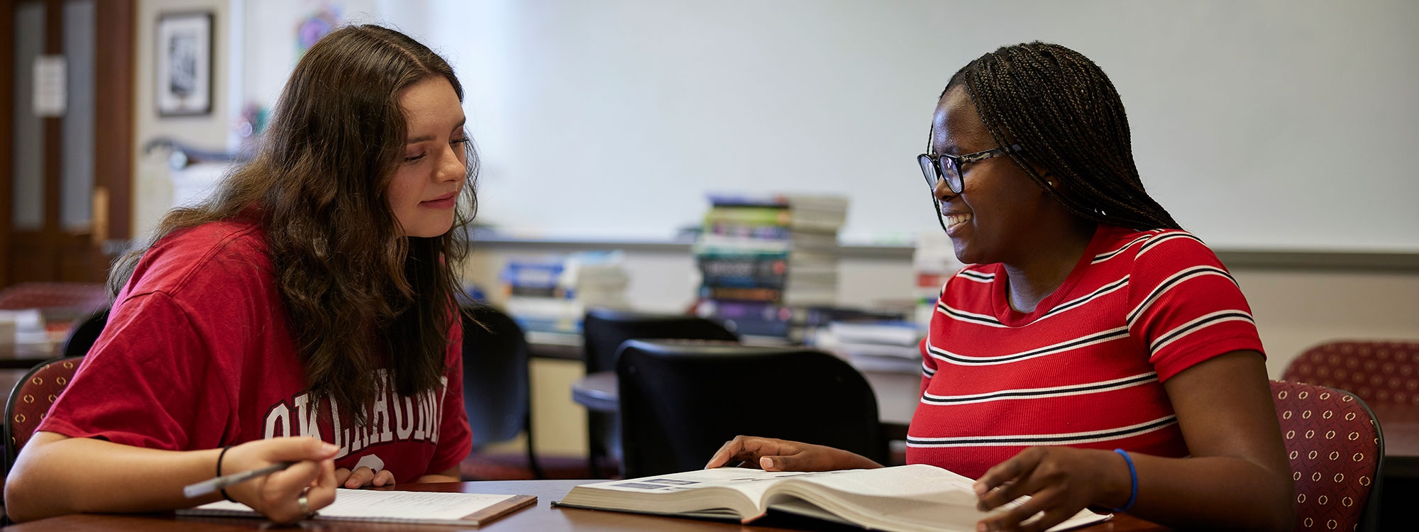 Two students sitting at a table with open books.