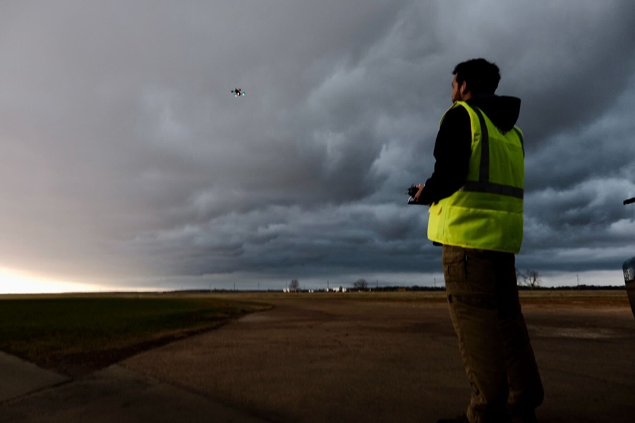 A pilot flying a drone into storm clouds.
