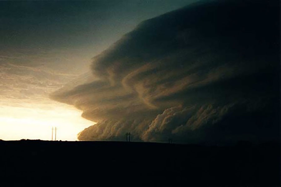Two dark columns of clouds touch the ground as they sweep across the countryside.