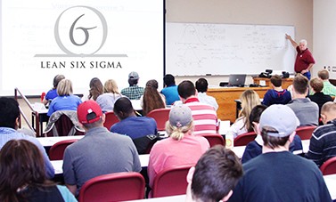 Dr. Mustafa Pulat at front of class writing on white board.