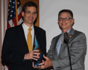 Stephen Luby holds Water Prize standing with Dean Tom Landers.