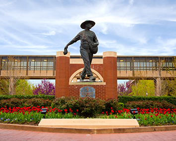 Seed sower statue in front of a skywalk on the HSC campus.