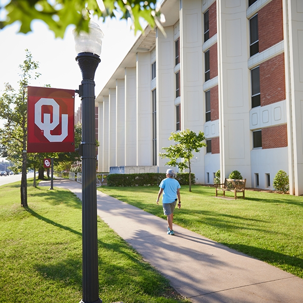 Student walking along the sidewalk next to Carson Engineering.