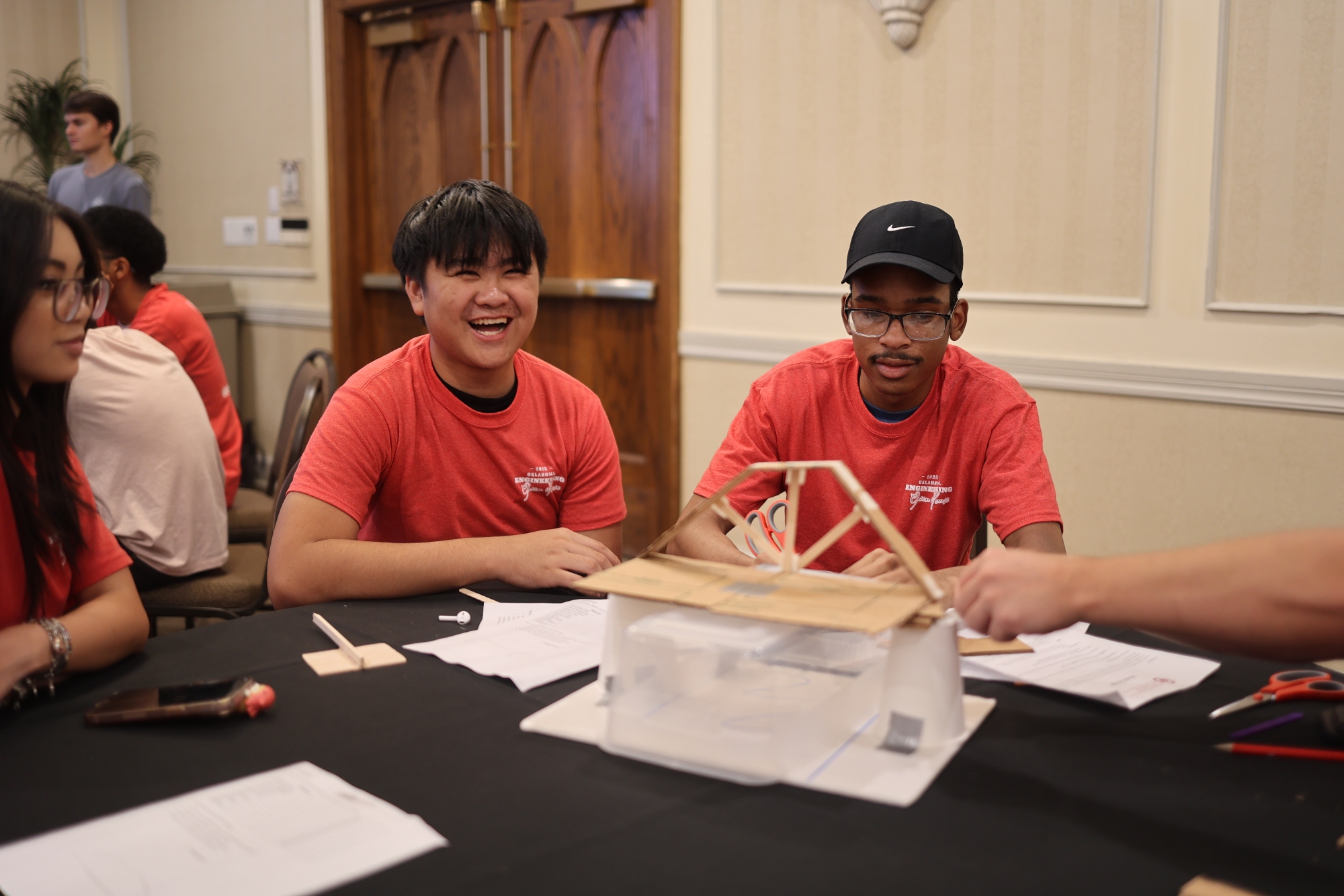 Students building model bridge for a model bridge building competition