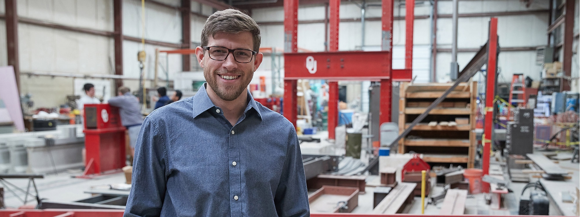 Young male standing in front of testing equipment in the Fears Lab.