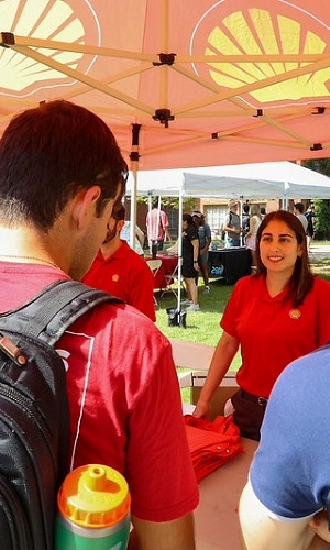 Students under a red tent at Fall Fest. 