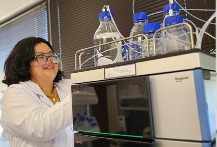 Researcher next to piece of equipment.